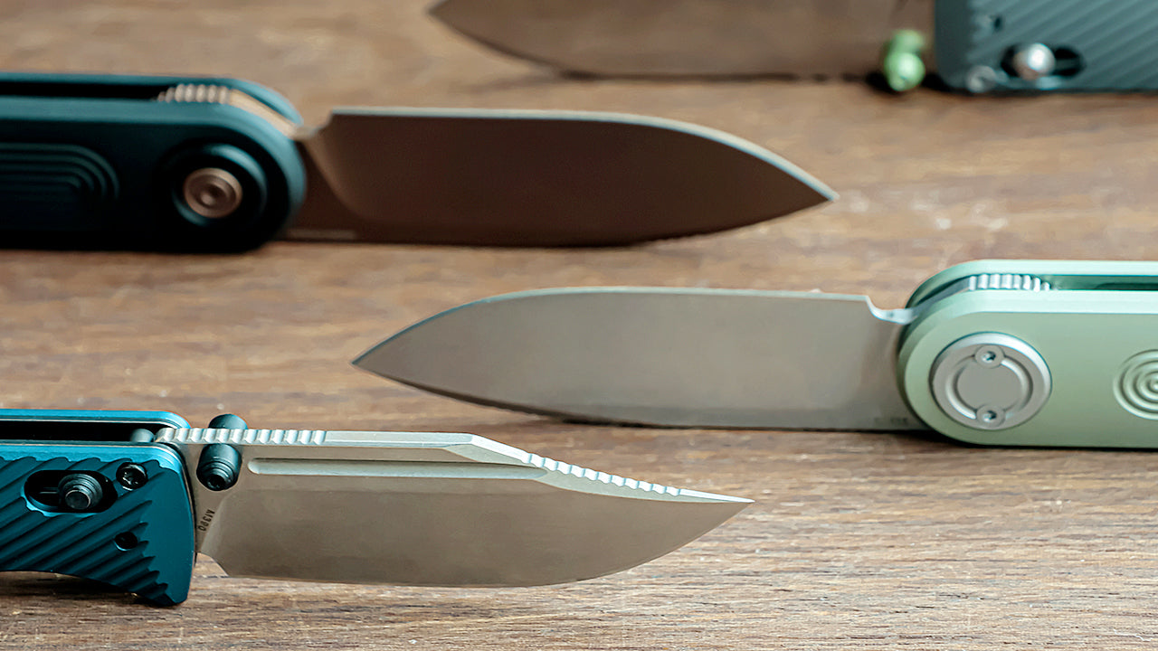 A close-up shot of several different pocket knife blades, highlighting various blade grinds and tip designs