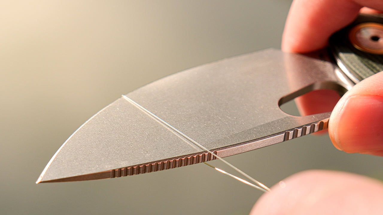 Close-up of a fishing knife blade cutting fishing line