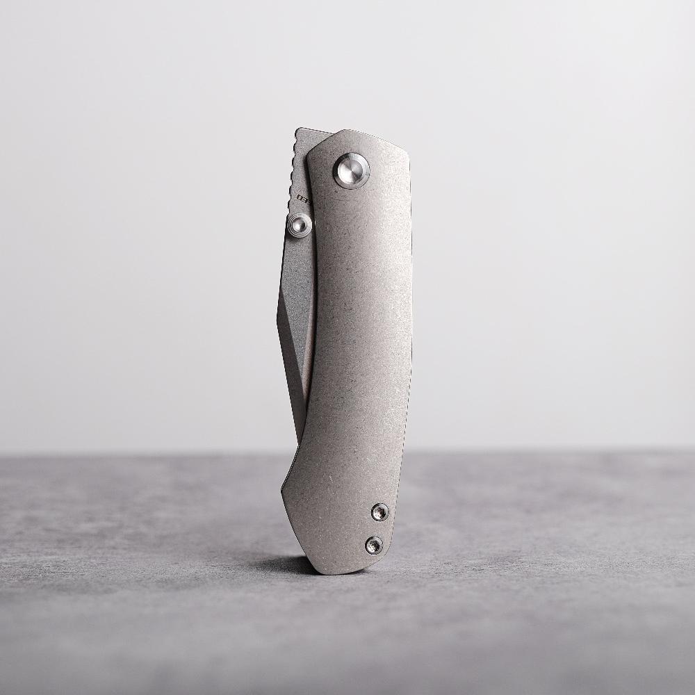 Vosteed Vallhund titanium frame lock knife on gray surface