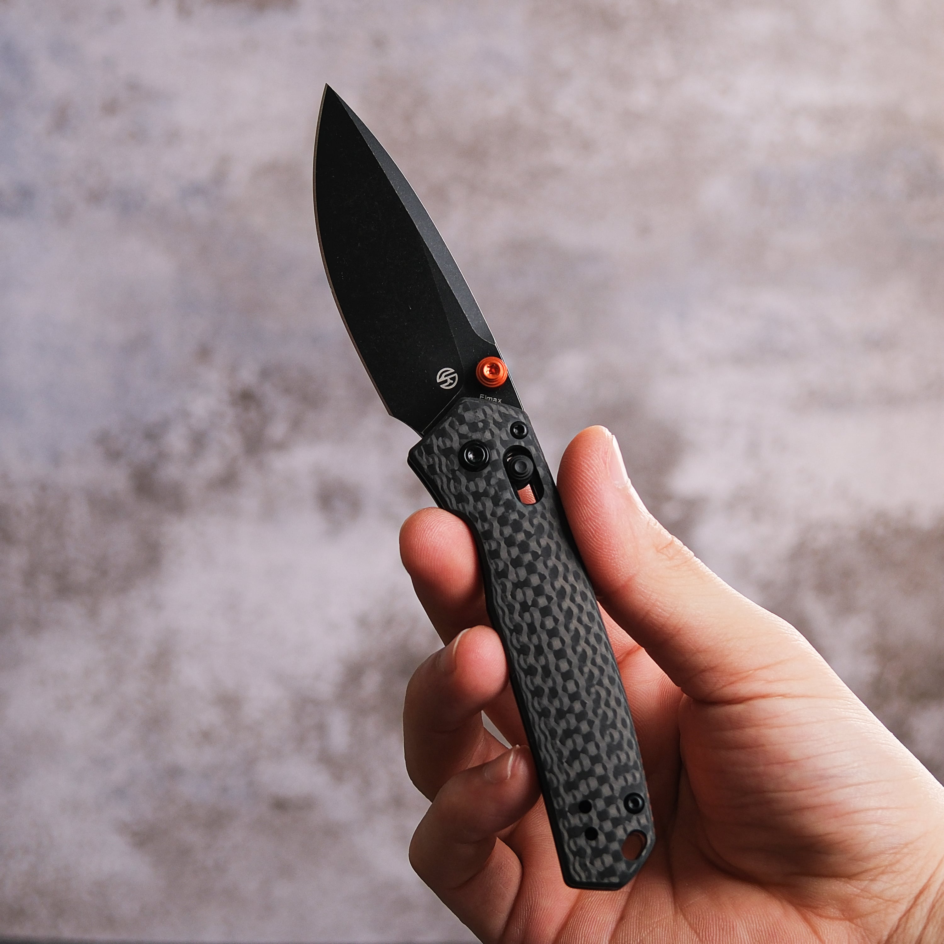 Vosteed Mini Psyop knife held in hand - Black blade and carbon fiber