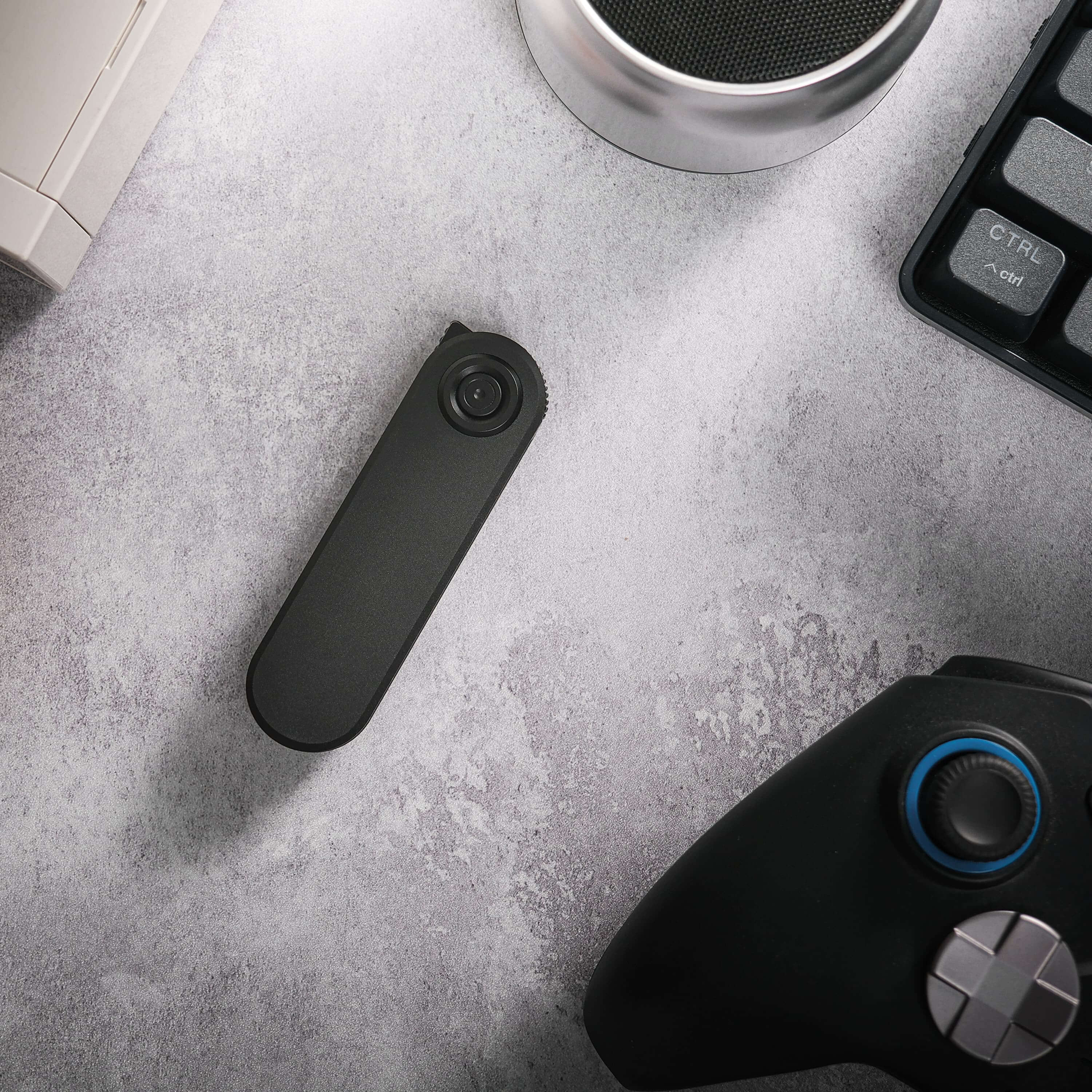 Corgi V knife on a desk with tech accessories