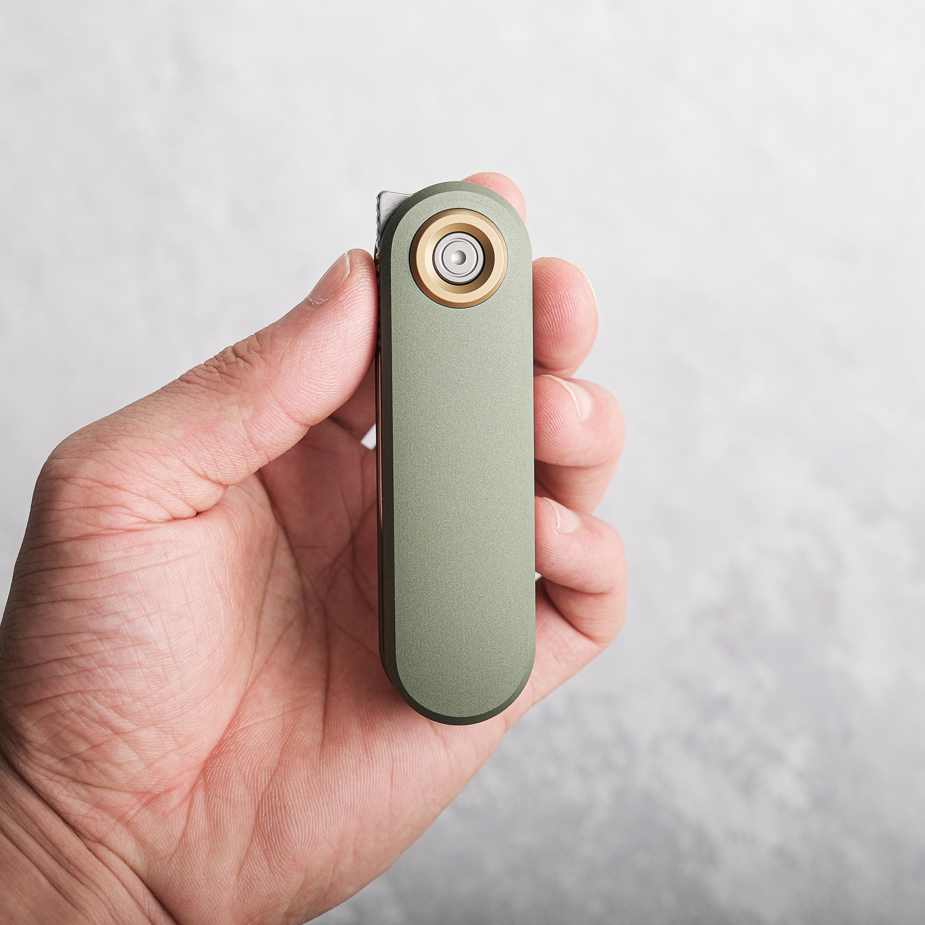 Vosteed Corgi V knife held in hand, green aluminum handle