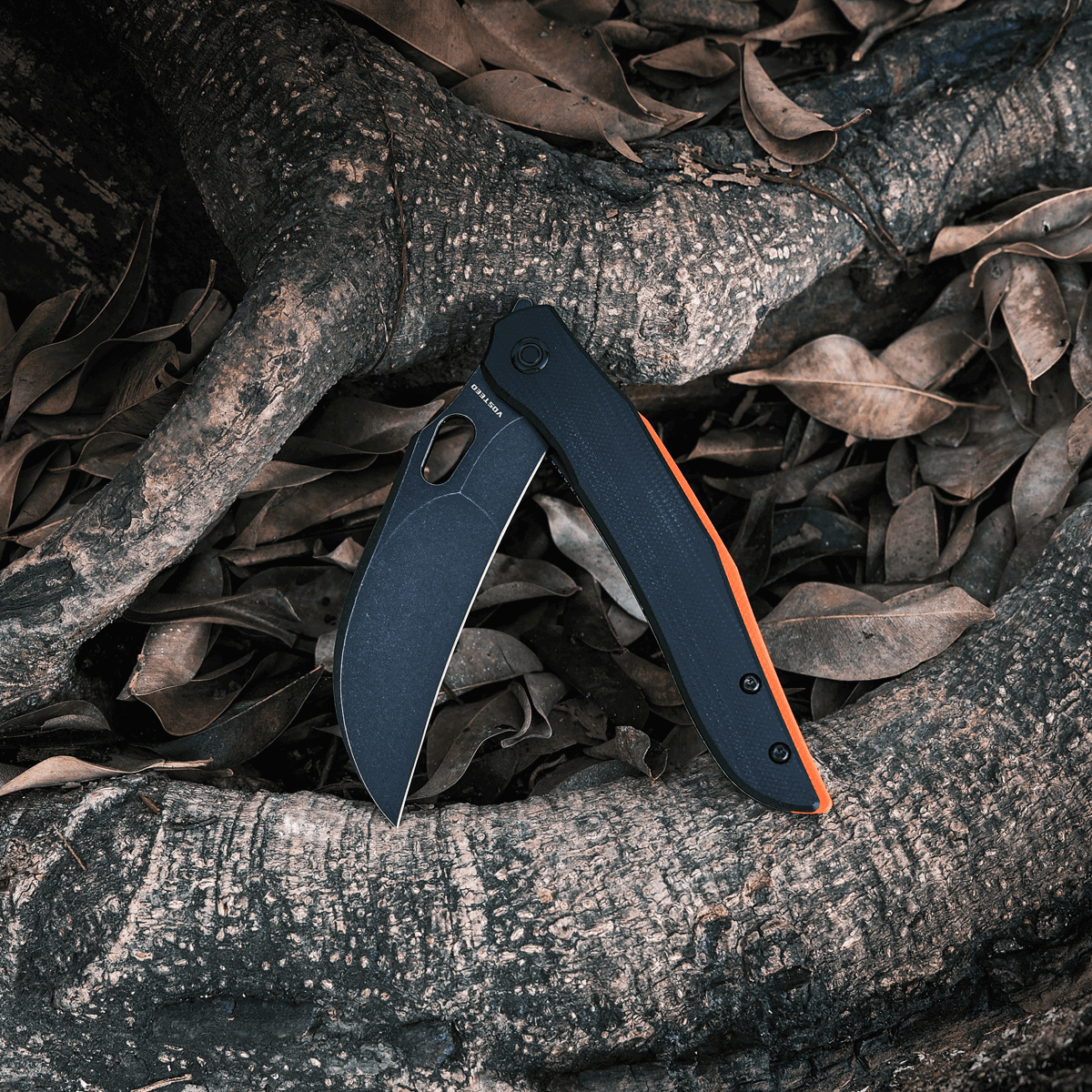 Vosteed Griffin hawkbill knife open on root background