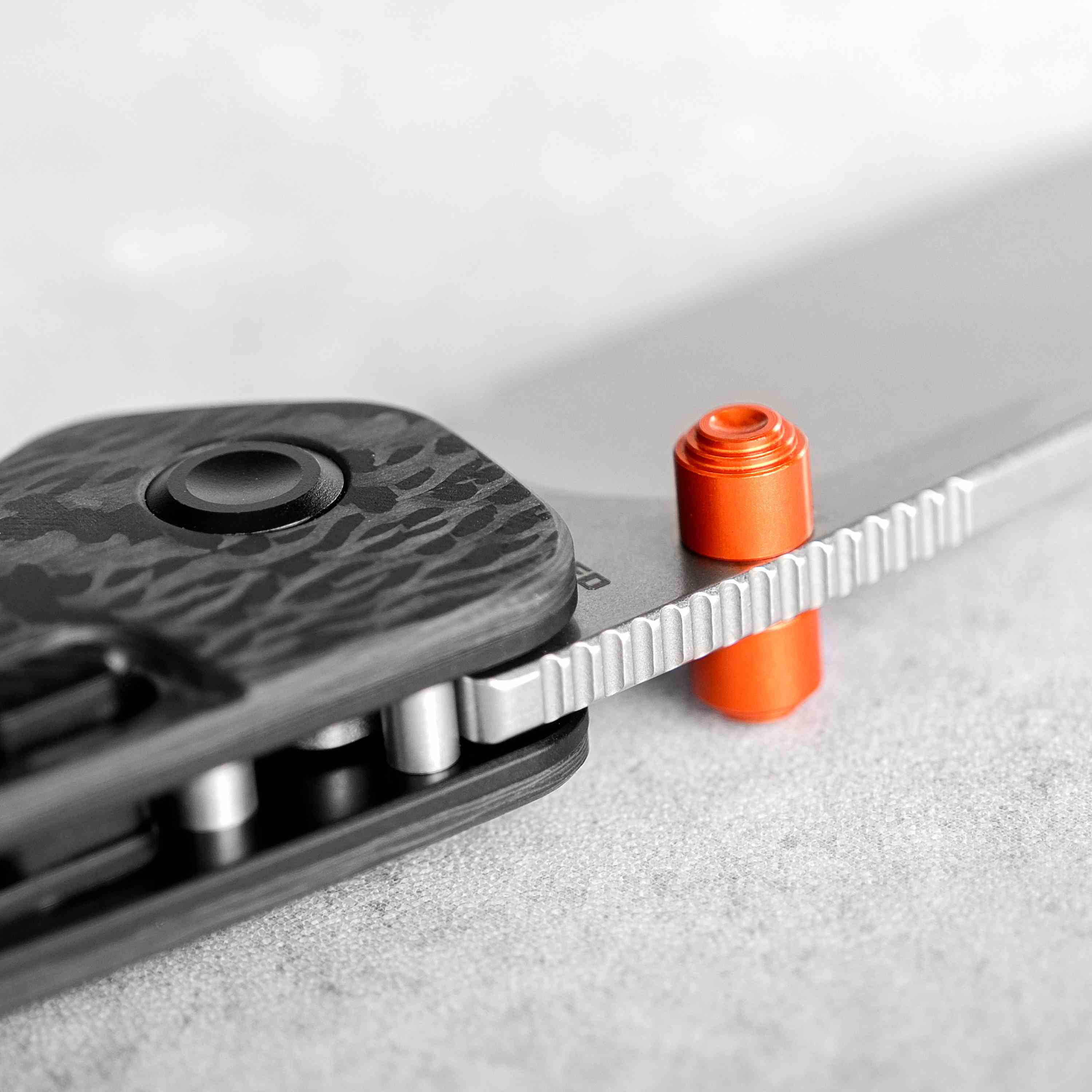 Vosteed Marten knife detail: button lock and orange backspacer