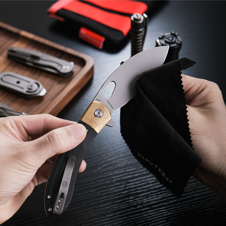 Vosteed Nightshade knife being cleaned with a cloth, Elmax blade