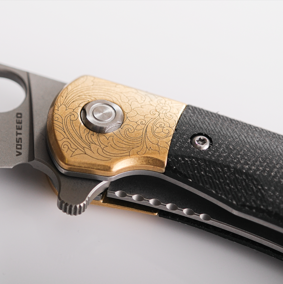 Vosteed Nightshade knife detail: brass bolster with floral design, Micarta handle