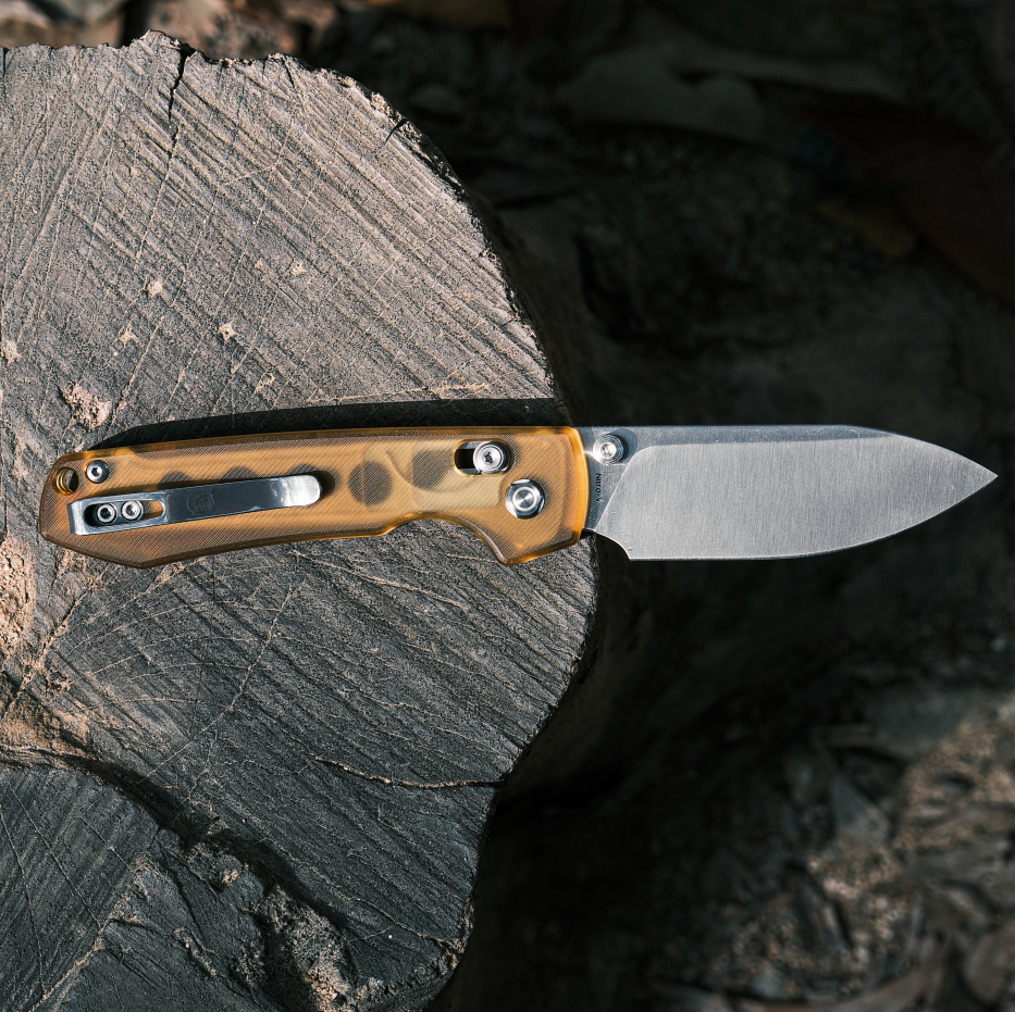 Vosteed Raccoon knife on wood: Amber PEI handle and stainless steel blade