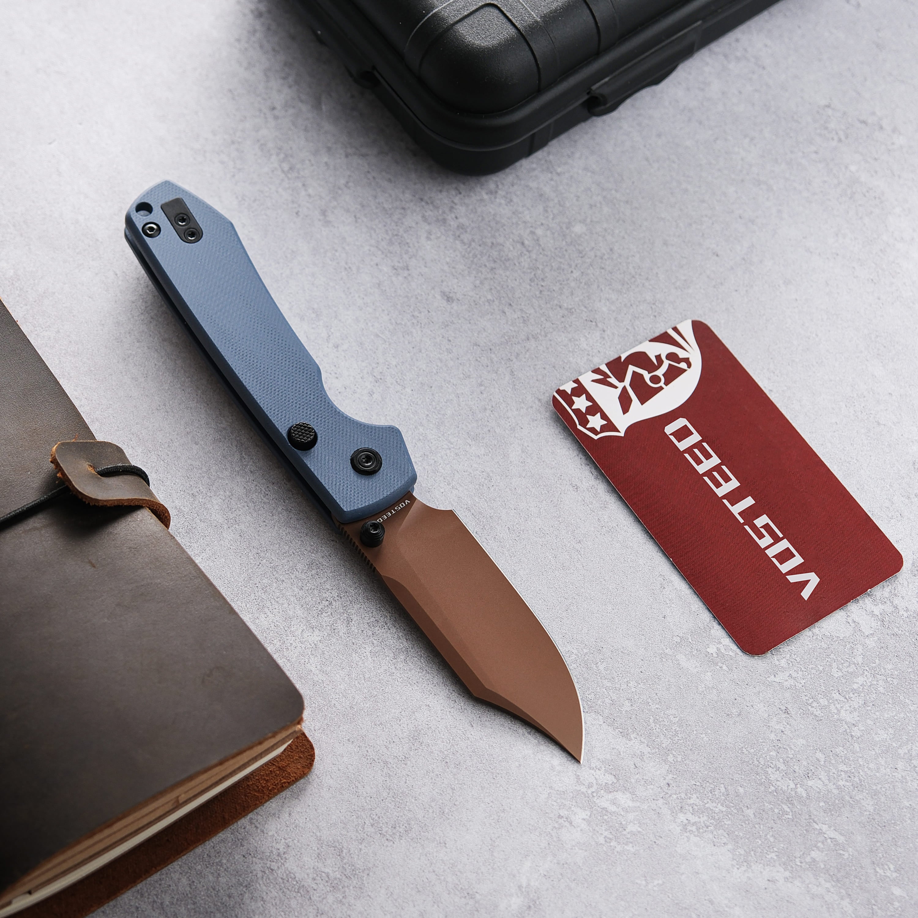 Vosteed Raccoon Knife with copper blade, next to Vosteed card