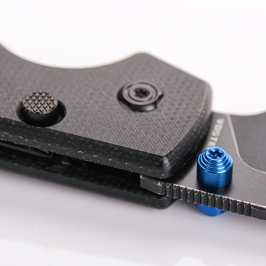 Vosteed Raccoon knife, blue thumb stud detail