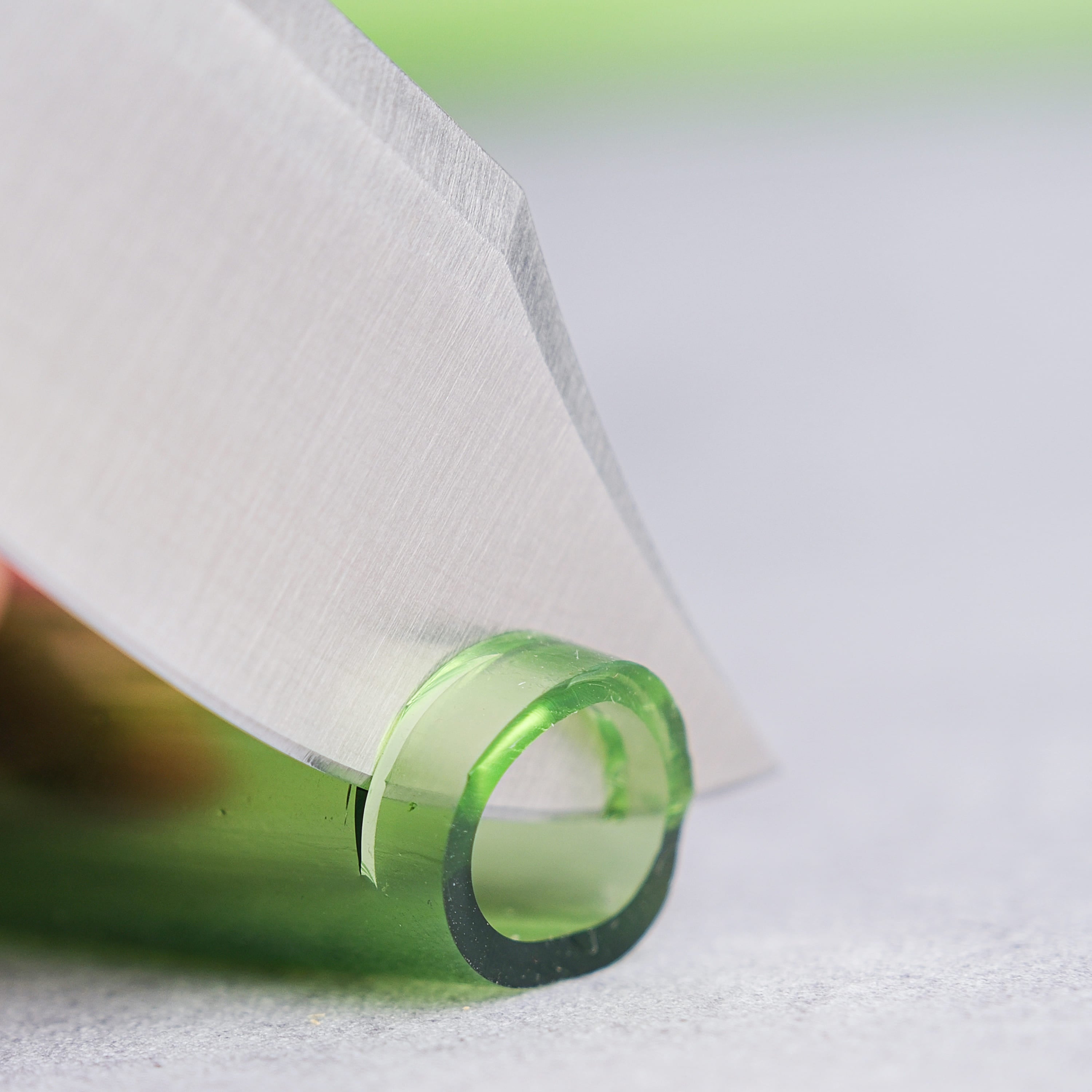 Vosteed Raccoon knife cutting green object, sharp blade