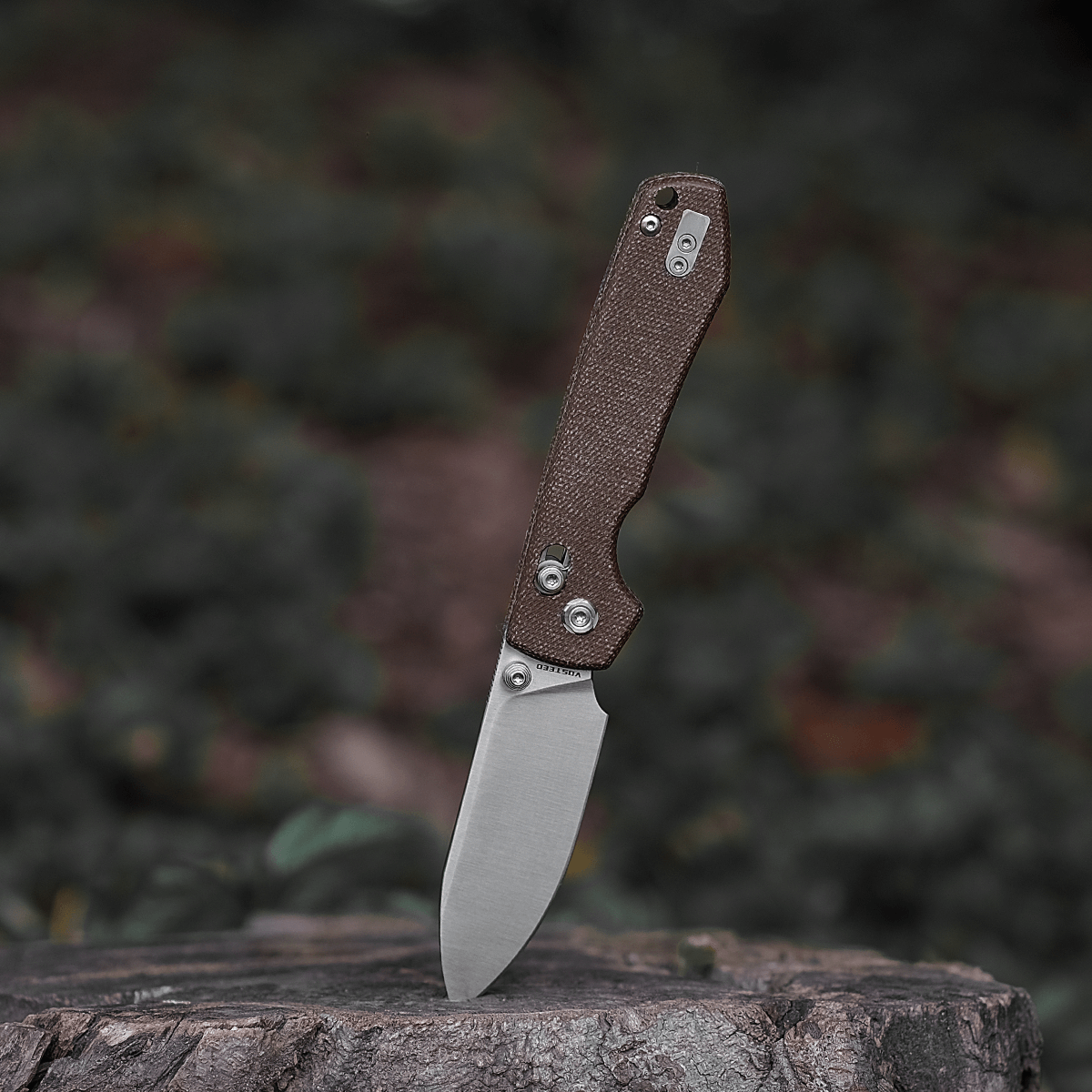 Vosteed Raccoon knife with Micarta handle on tree stump