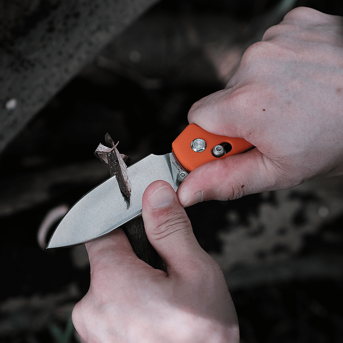 Vosteed Raccoon knife cutting a small branch.