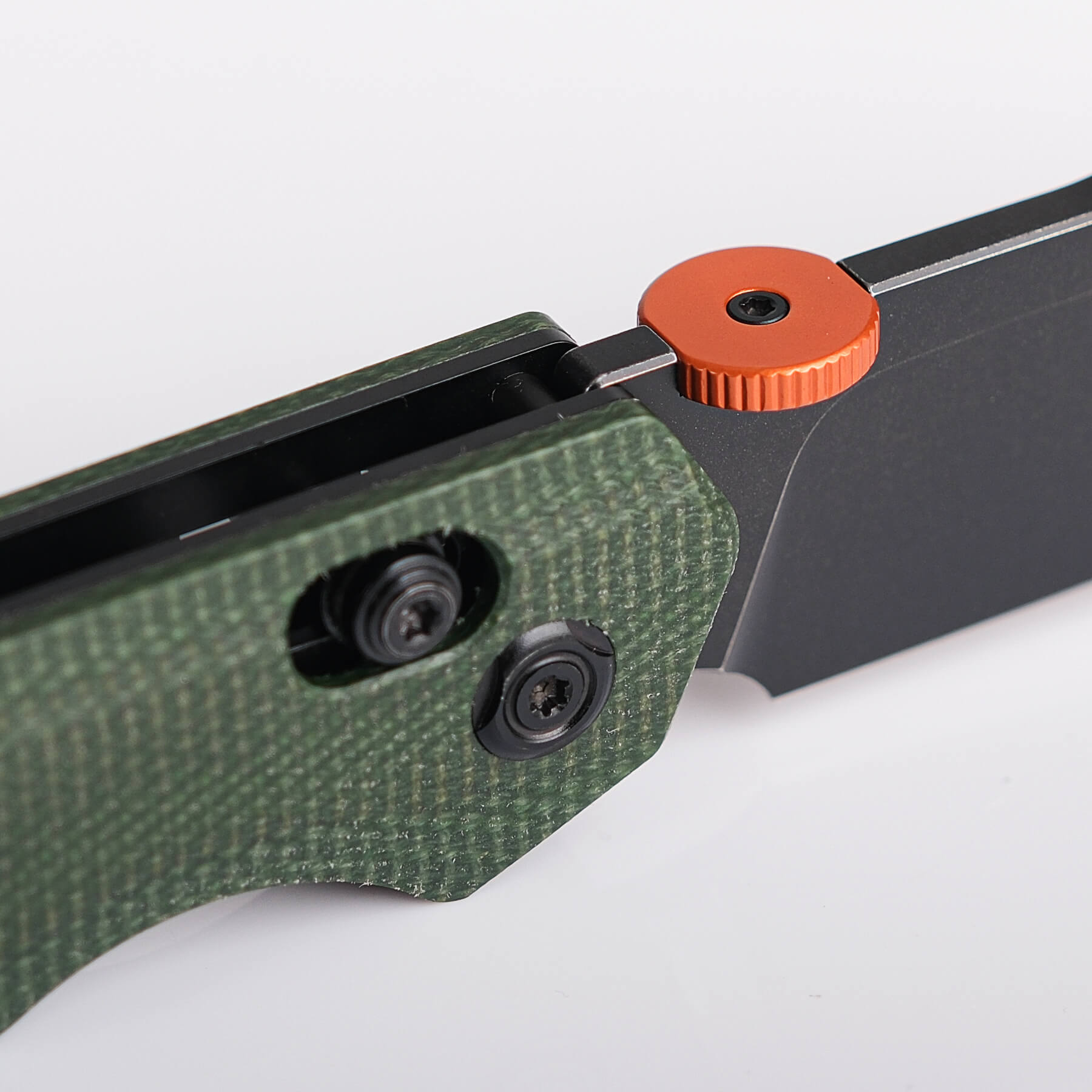 Close-up of Vosteed Tala knife blade, handle, and thumb disk, Green Micarta