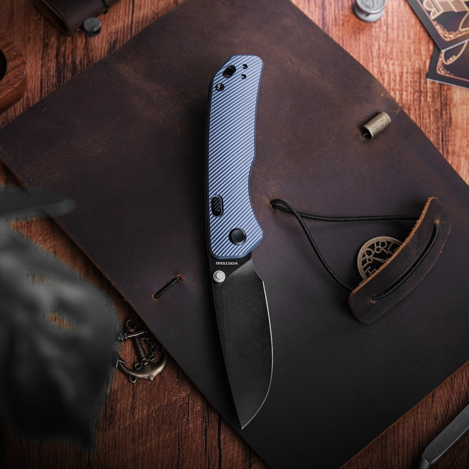 Vosteed Marten EDC knife, blue handle and black blade on leather