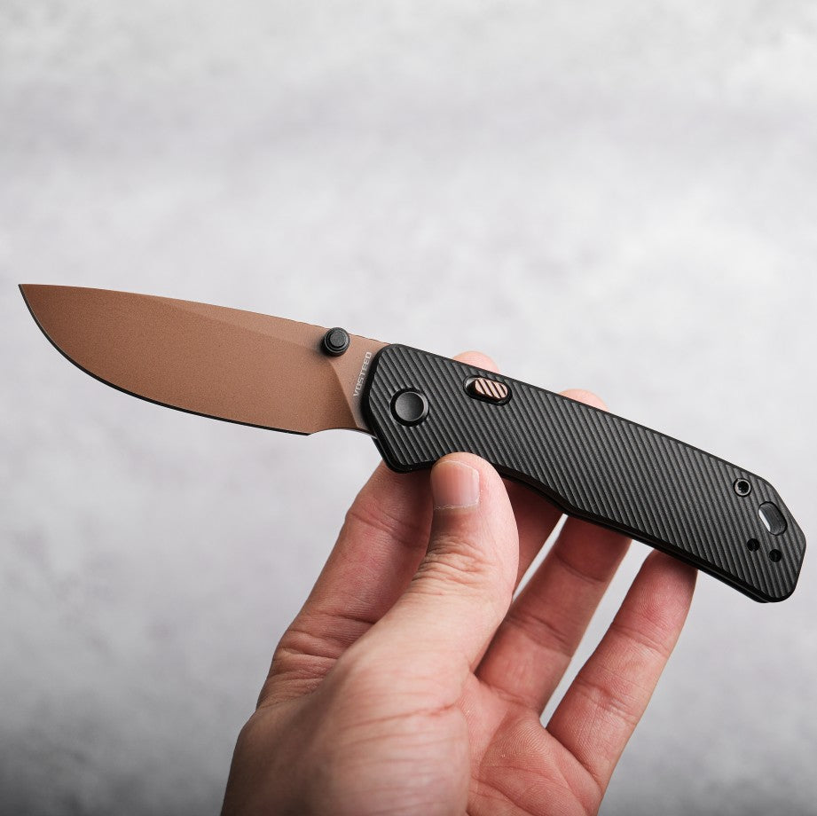 Vosteed Marten knife open, copper blade and black handle held in hand
