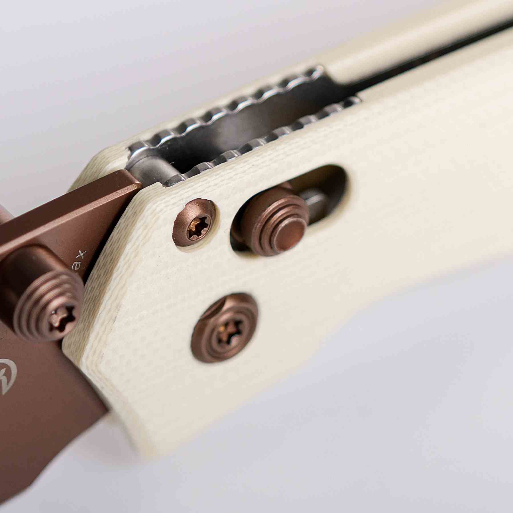 Mini Psyop knife detail: Copper Dune hardware on white handle