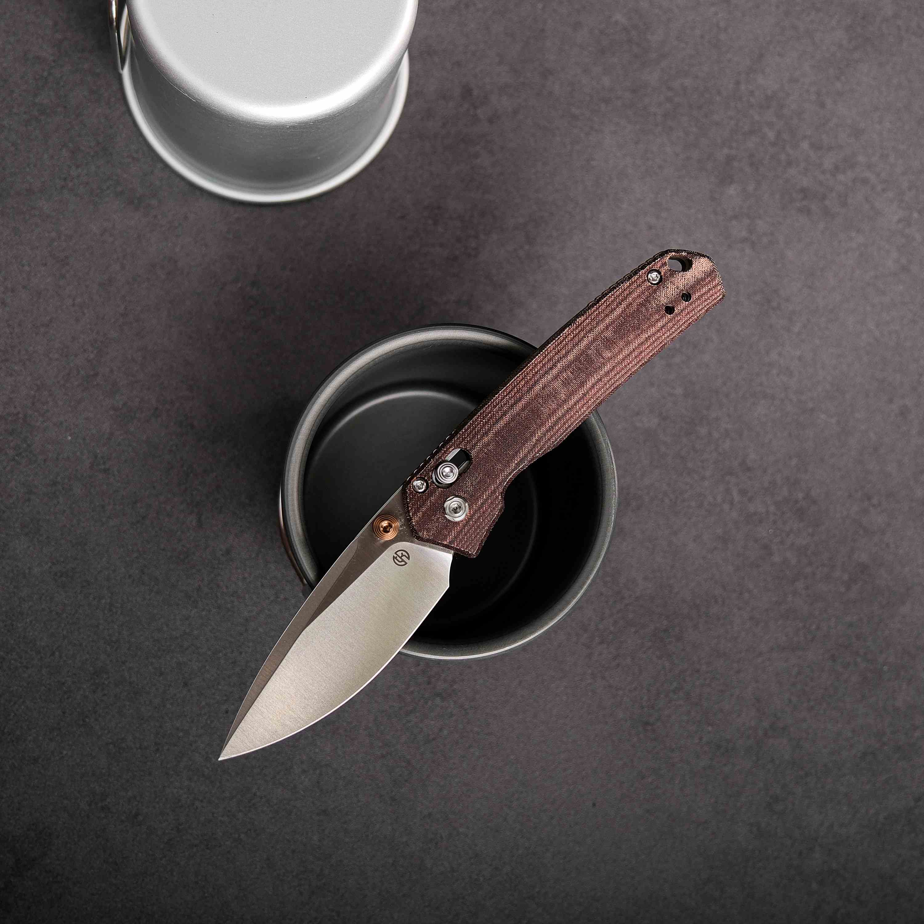 Maroon Micarta Vosteed Mini Psyop knife, blade, and cup detail