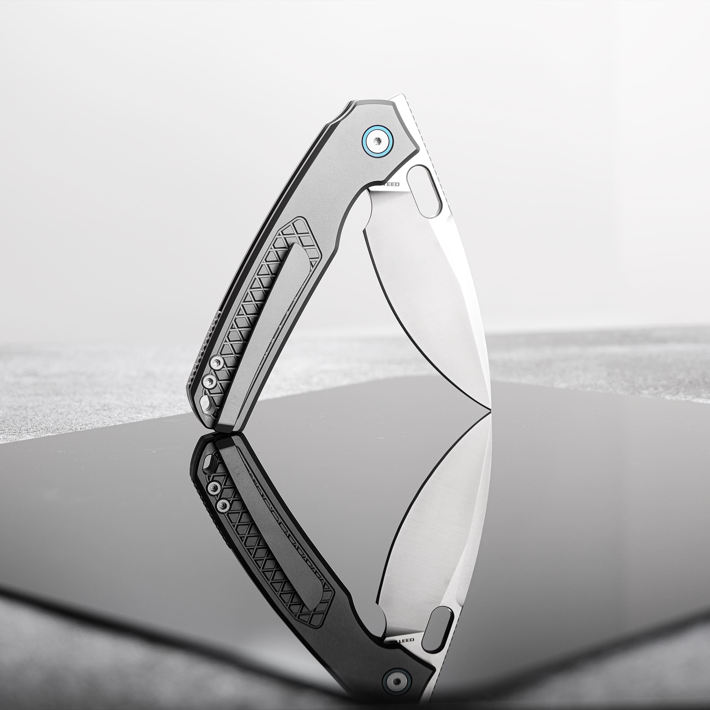 Vosteed Psyop knife, open blade, titanium handle, and reflection.