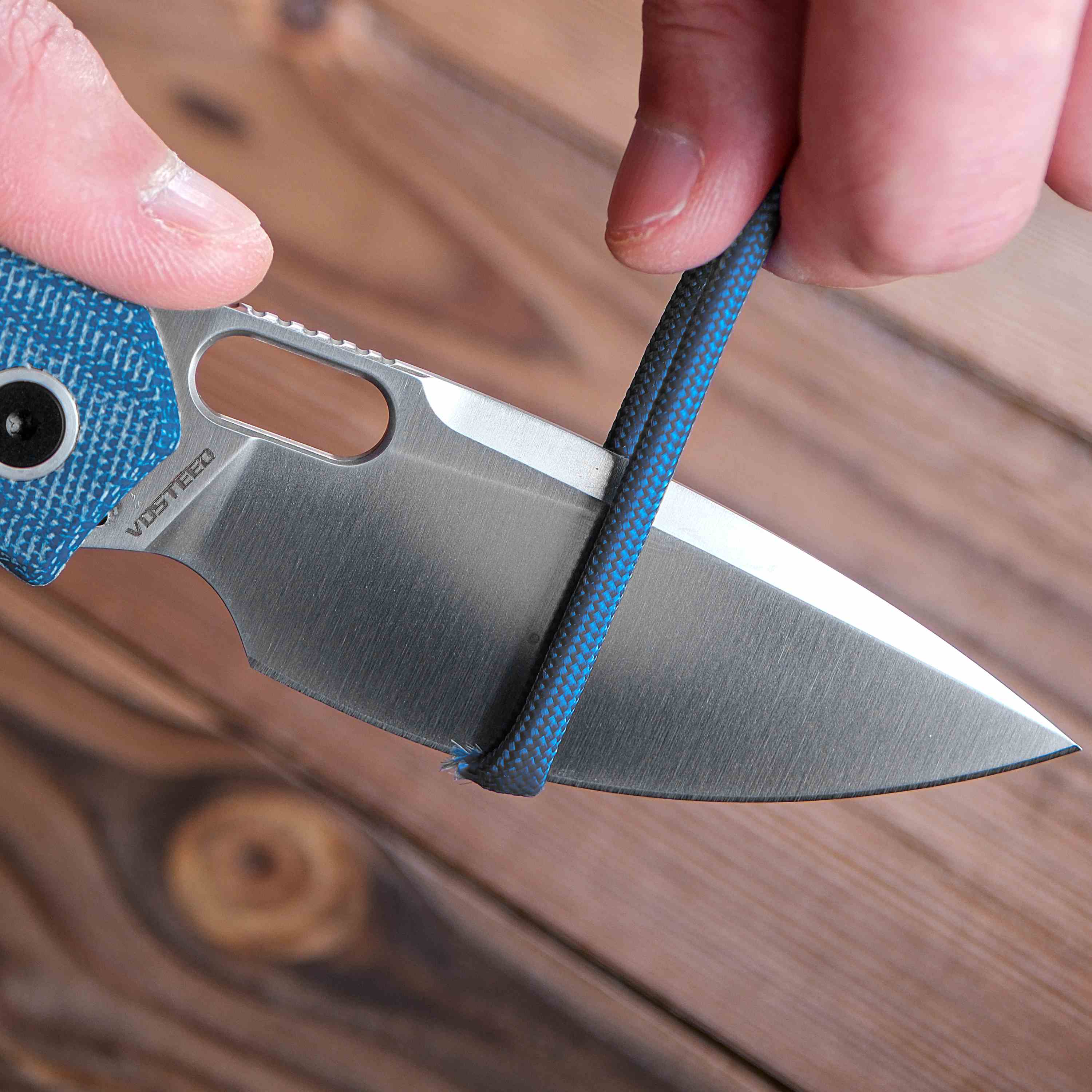 Vosteed Psyop knife blade cutting through a blue rope