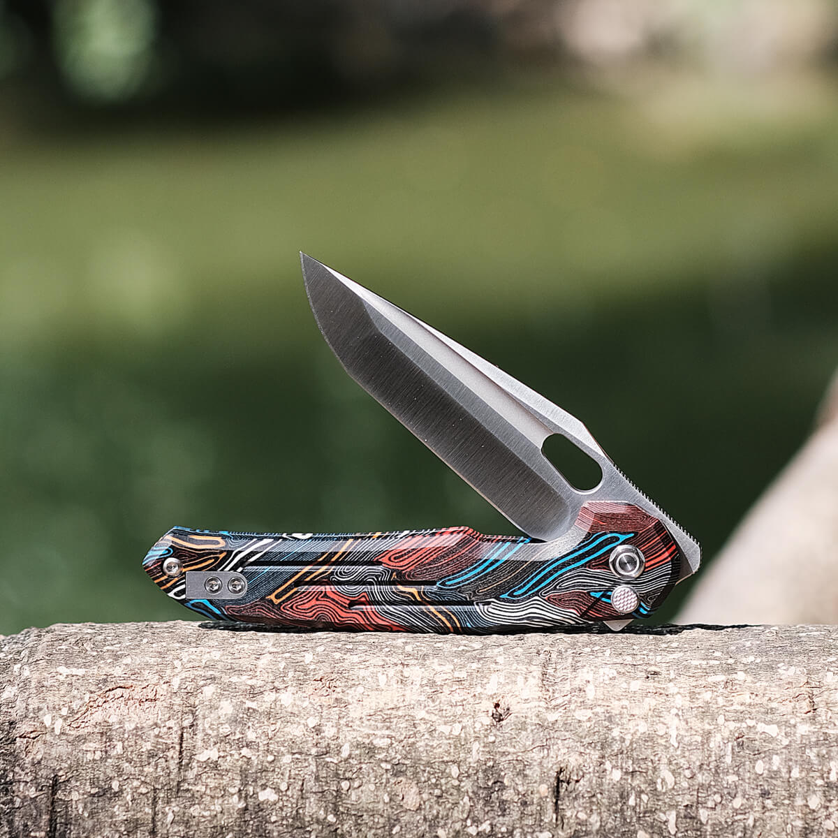 Vosteed Thunderbird knife, blade open on a tree trunk